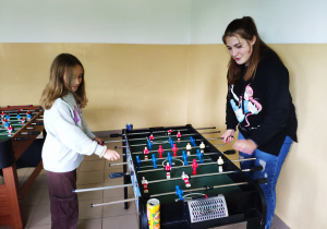 Uczennice grające w piłkarzyki stołowe.